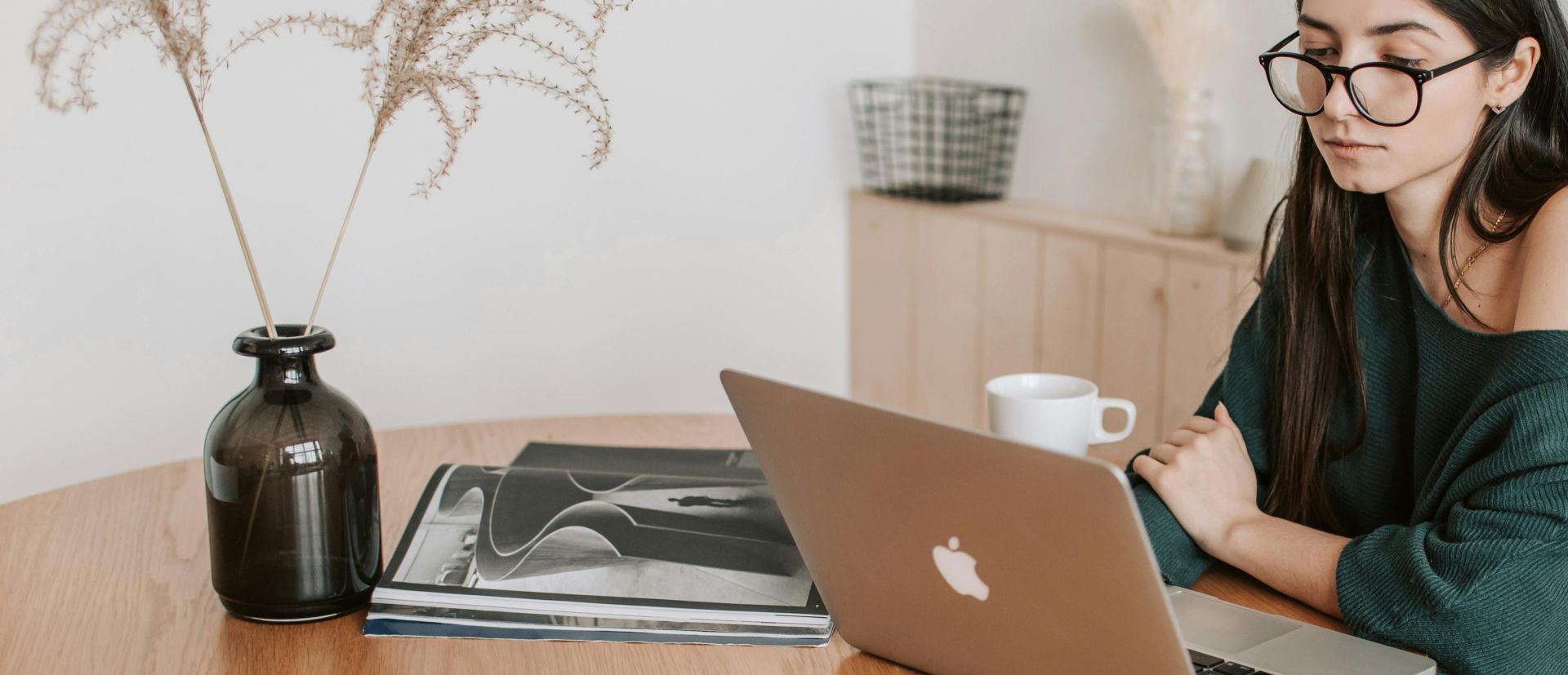 Thoughtful female freelancer watching laptop in light room at home